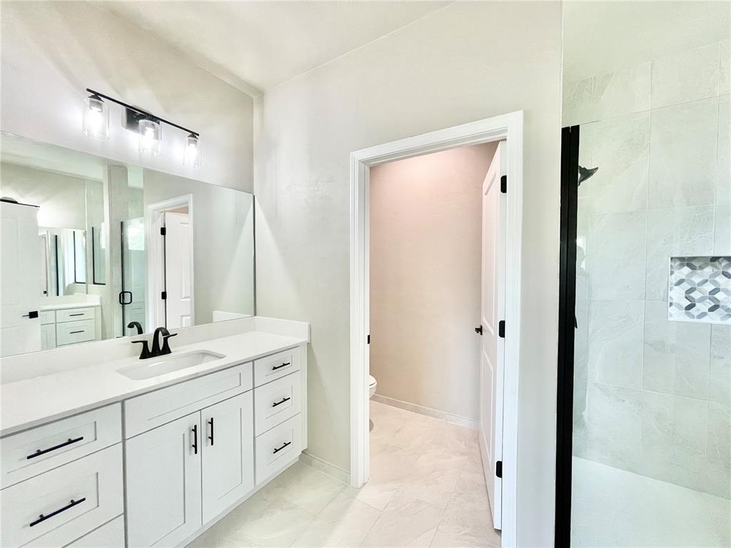 1021 Southwest 67th Street Gainesville, FL 32607 - Photo 15 of 53 a spacious bathroom with a granite countertop sink mirror and a