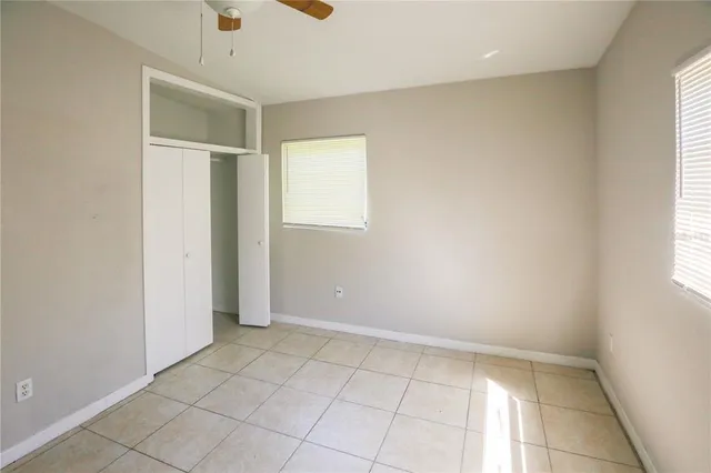 an empty room with windows and closet