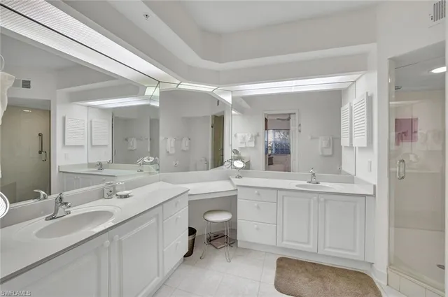 a bathroom with a sink double vanity granite tub shower and a mirror