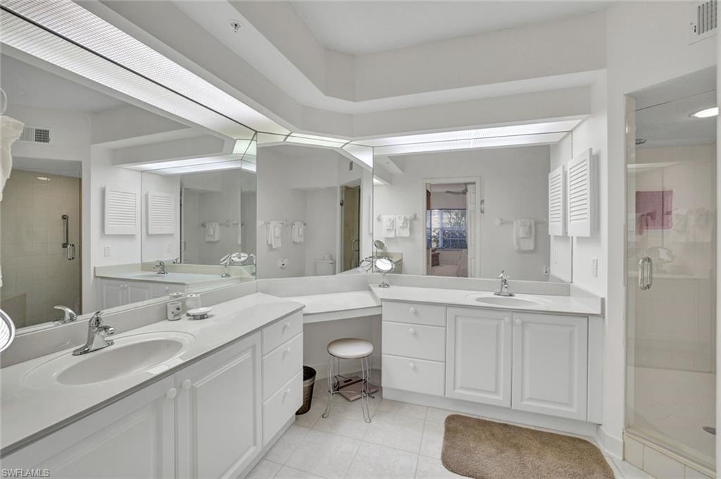 6883 Redbay Park Road, Unit 102 Naples, FL 34109 - Photo 11 of 22 a bathroom with a sink double vanity granite tub shower and a mirror
