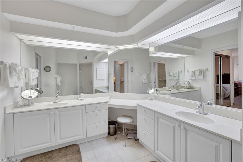 6883 Redbay Park Road, Unit 102 Naples, FL 34109 - Photo 12 of 22 a spacious bathroom with a double vanity sink and a mirror