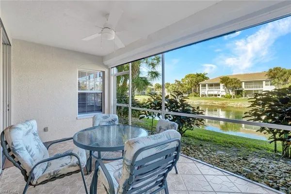 a living room with patio furniture and a floor to ceiling window