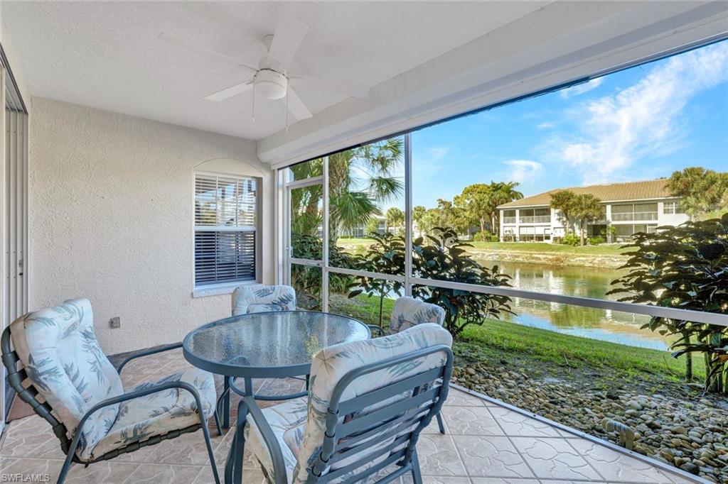 6883 Redbay Park Road, Unit 102 Naples, FL 34109 - Photo 17 of 22 a living room with patio furniture and a floor to ceiling window