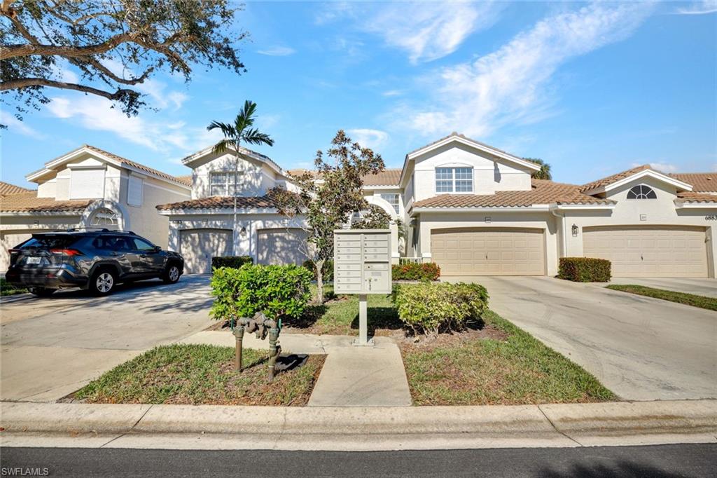 6883 Redbay Park Road, Unit 102 Naples, FL 34109 - Photo 3 of 22 a front view of a house with garden