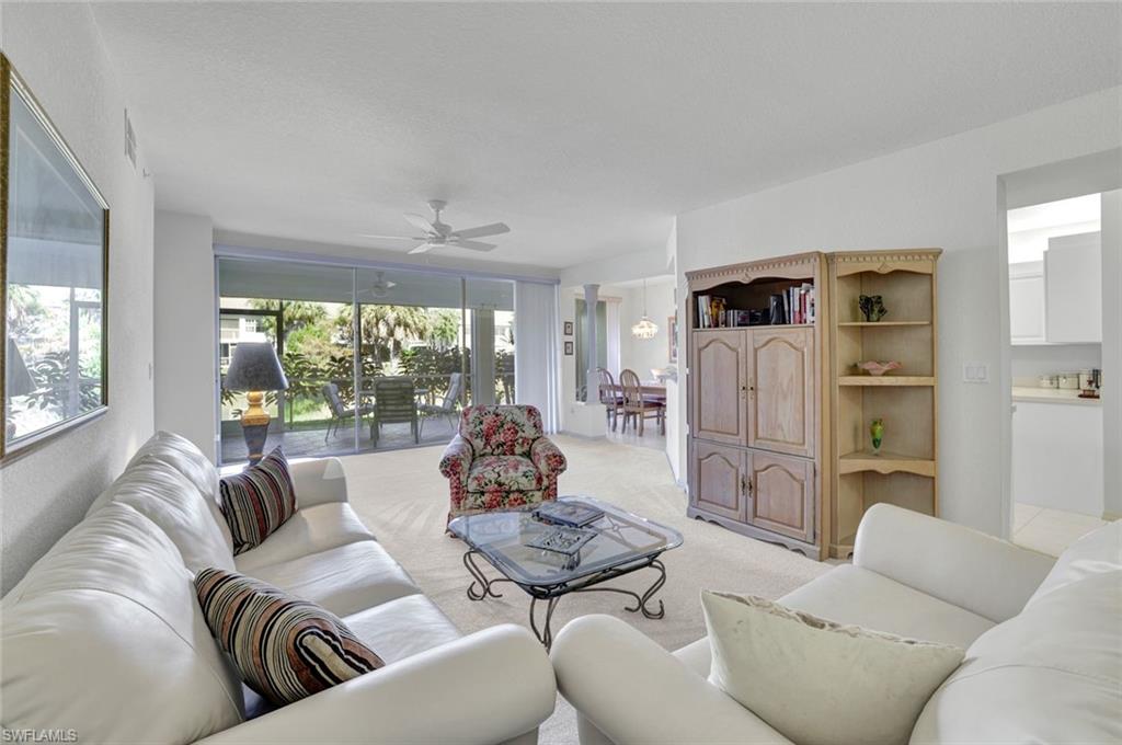 6883 Redbay Park Road, Unit 102 Naples, FL 34109 - Photo 4 of 22 a living room with furniture and a large window