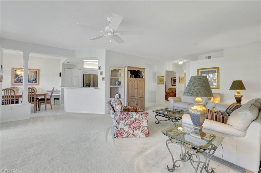 6883 Redbay Park Road, Unit 102 Naples, FL 34109 - Photo 5 of 22 a living room with furniture and wooden floor