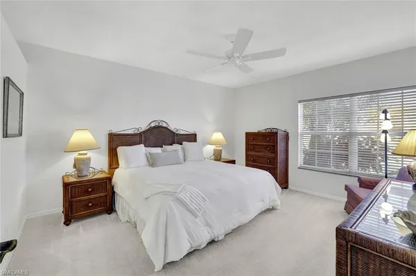 a bedroom with bed and a large window