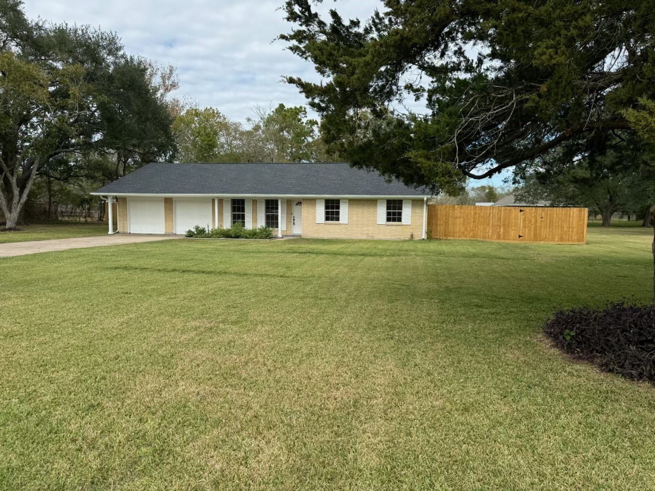 a front view of house with yard and trees all around