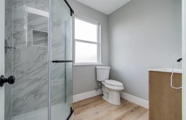 a bathroom with a toilet and a shower