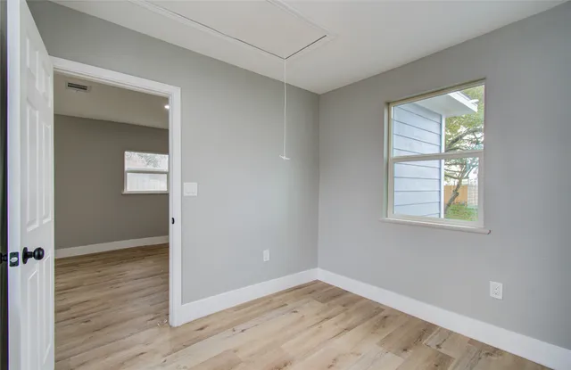 wooden floor in an empty room with a window