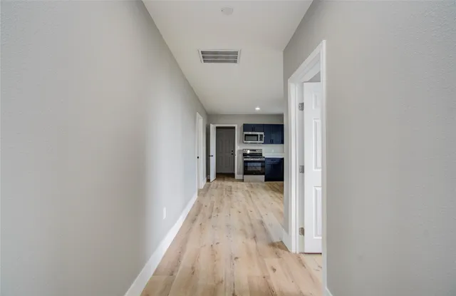 a view of a hallway with wooden floor