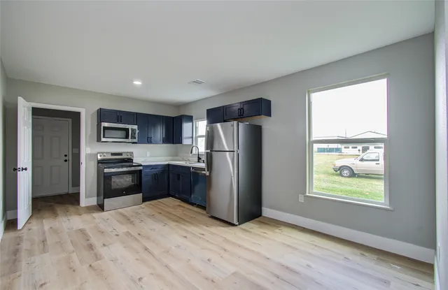 a kitchen with stainless steel appliances granite countertop a refrigerator and a stove top oven