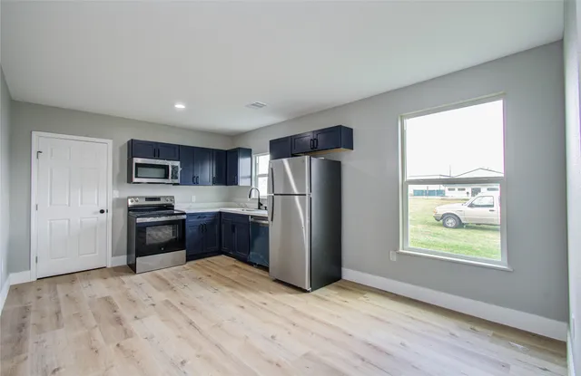 a kitchen with stainless steel appliances granite countertop a refrigerator microwave and sink