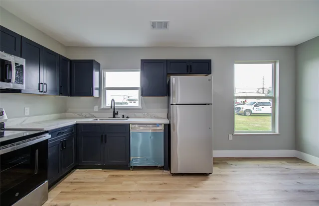a kitchen with stainless steel appliances granite countertop a refrigerator sink and cabinets