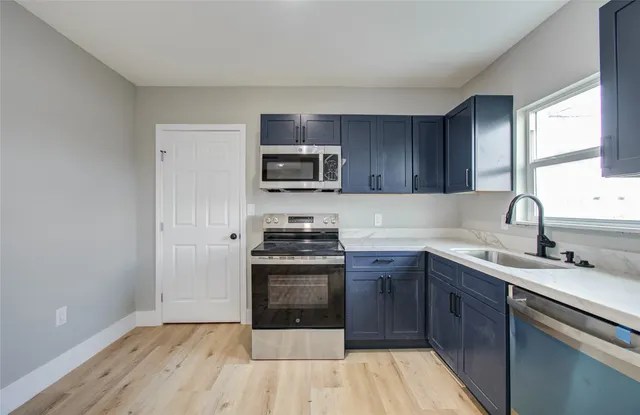 a kitchen with a sink stove and microwave