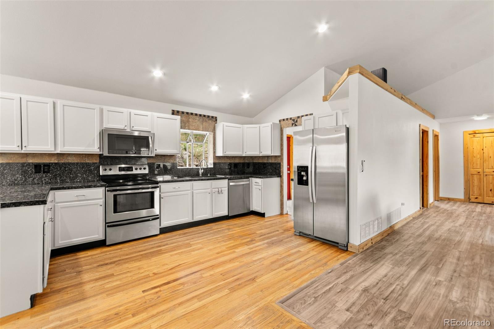 202 Badger Lane Bailey, CO 80421 - Photo 6 of 50 a kitchen with granite countertop a refrigerator and a stove top oven