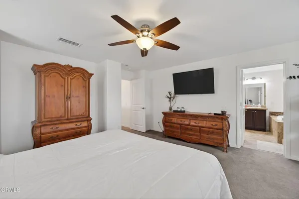 a bedroom with a large bed and flat screen tv