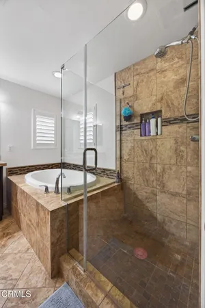 a spacious bathroom with a granite countertop sink a mirror and shower