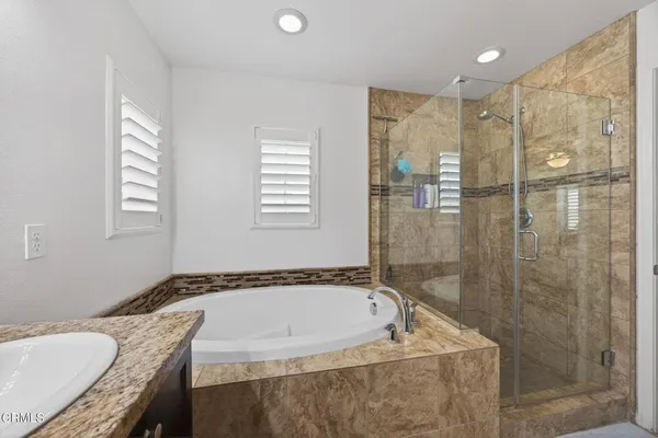 a bathroom with a granite countertop tub a sink and a granite