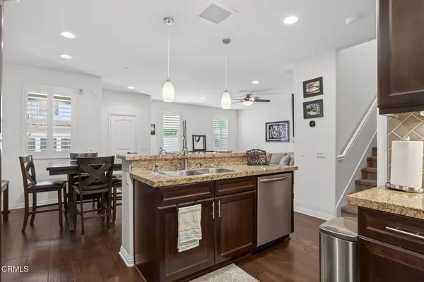 a kitchen with granite countertop a stove and chairs