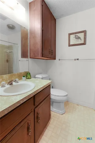 a bathroom with a granite countertop sink a toilet and mirror