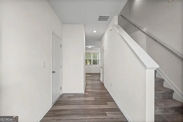 a view of a hallway with wooden floor and staircase