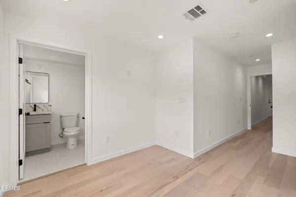 a view of a kitchen from the hallway with a bathroom and a sink