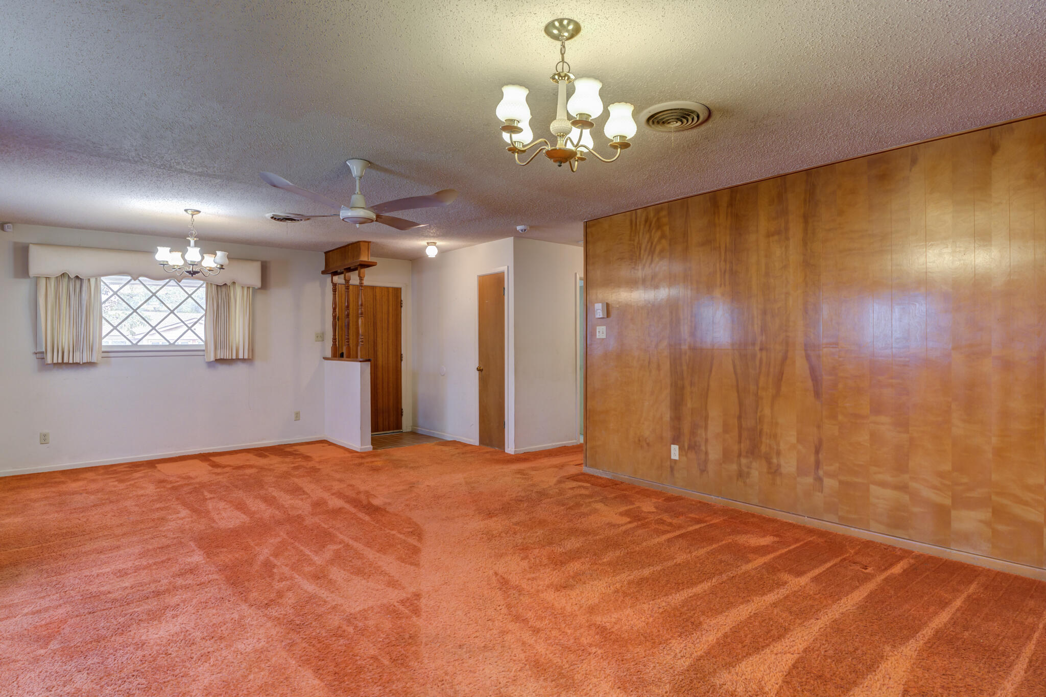 5502 8th Street Lubbock, TX 79416 - Photo 12 of 37 a view of a big room with a chandelier fan and windows