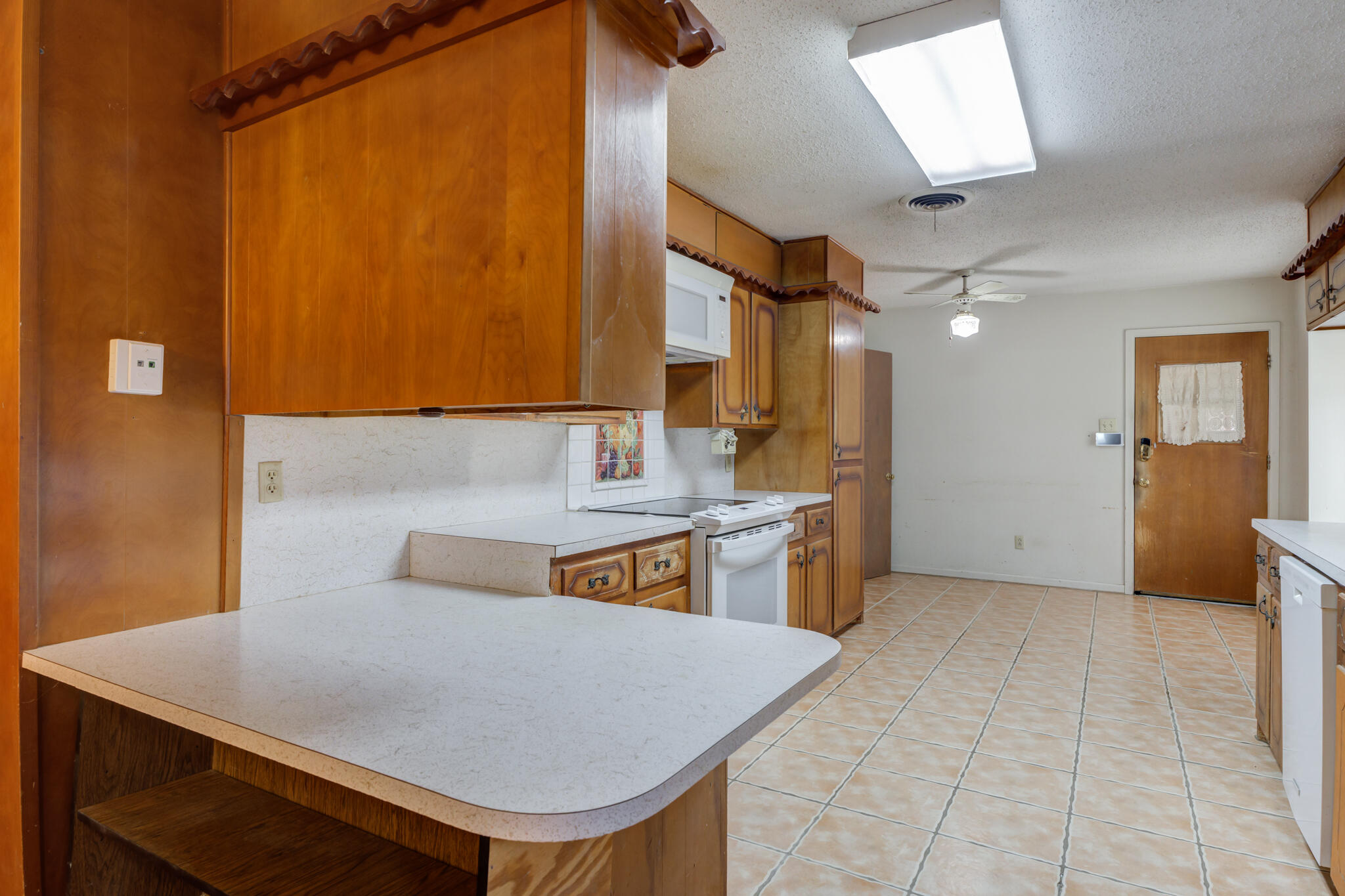 5502 8th Street Lubbock, TX 79416 - Photo 14 of 37 a kitchen with kitchen island a sink a stove and a refrigerator