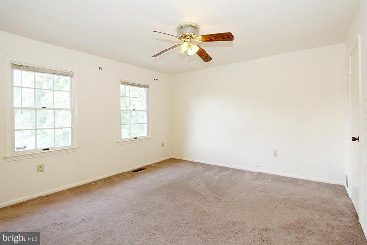 8955 Rolling Road Manassas, VA 20110 - Photo 16 of 30 an empty room with chandelier fan and windows