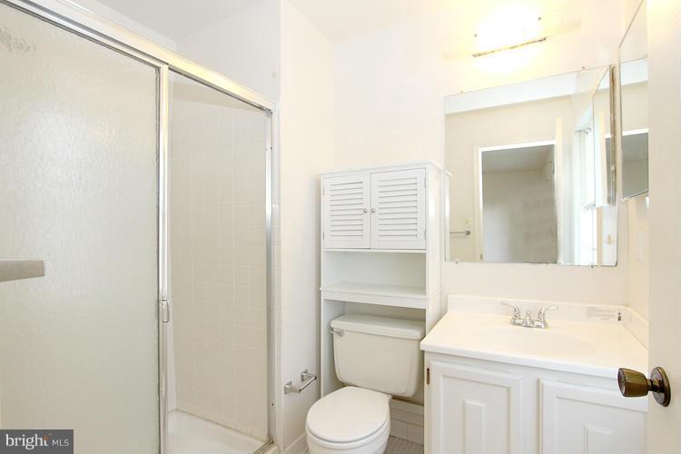 8955 Rolling Road Manassas, VA 20110 - Photo 17 of 30 a bathroom with a toilet a sink and mirror