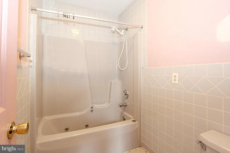 8955 Rolling Road Manassas, VA 20110 - Photo 21 of 30 a bathroom with a bathtub and a shower