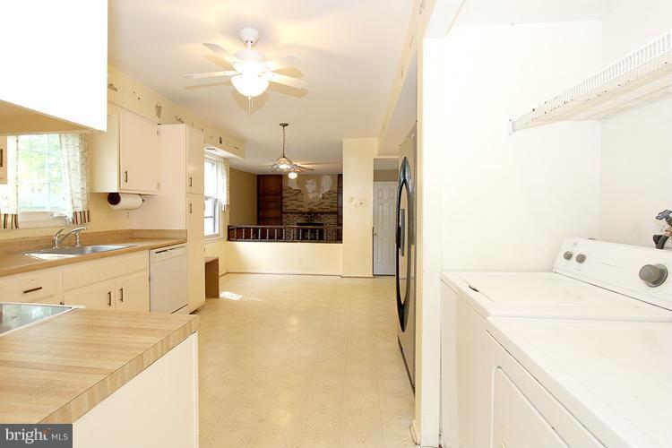 8955 Rolling Road Manassas, VA 20110 - Photo 7 of 30 a large white kitchen with a sink and chandelier