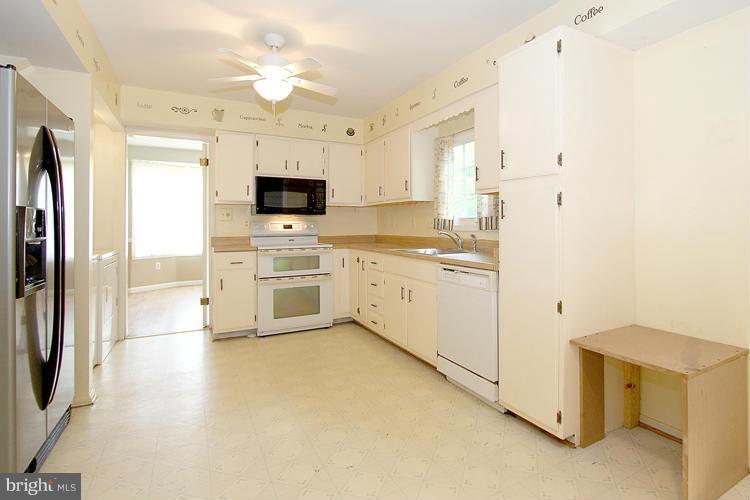 8955 Rolling Road Manassas, VA 20110 - Photo 9 of 30 a kitchen with a stove a sink and a refrigerator