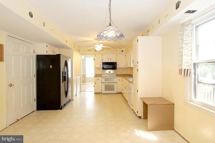 8955 Rolling Road Manassas, VA 20110 - Photo 10 of 30 a view of a hallway with wooden floor and a kitchen