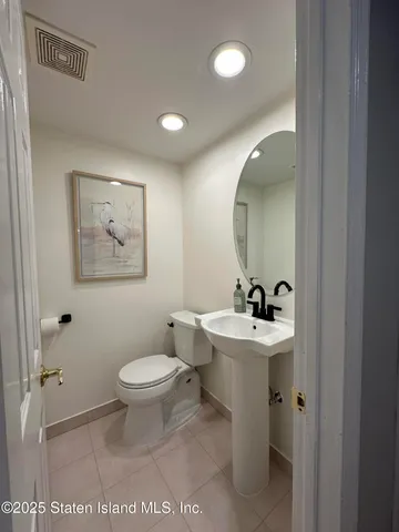 a bathroom with a toilet a sink and mirror