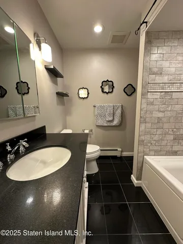 a bathroom with a sink a toilet a mirror and shower