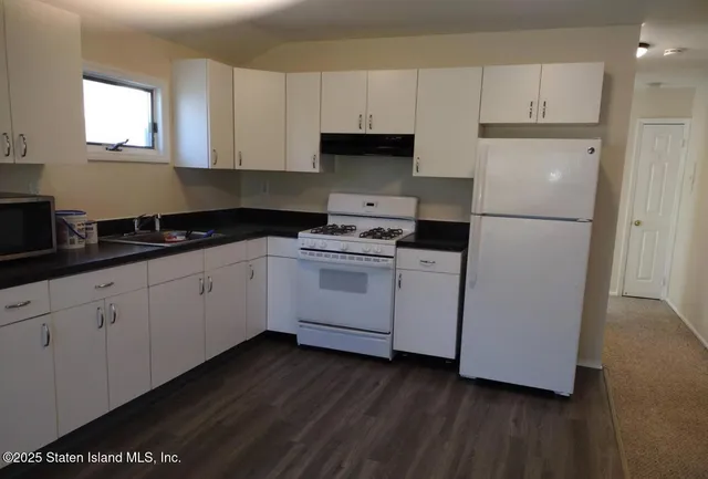 a kitchen with cabinets appliances and a window