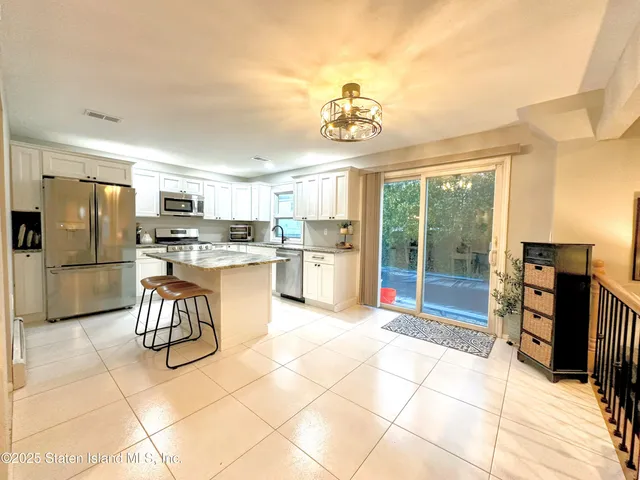 a kitchen with stainless steel appliances granite countertop a refrigerator and a stove top oven