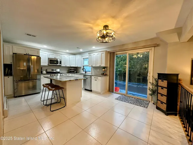 a kitchen with stainless steel appliances granite countertop a refrigerator and a stove top oven