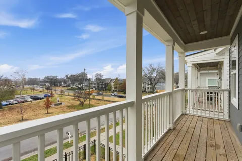 a view of a porch with wooden floor and floor to ceiling window