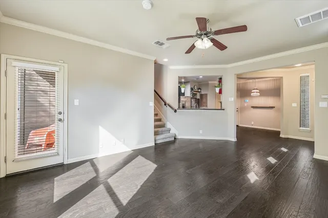 a view of a livingroom with wooden floor and a ceiling fan