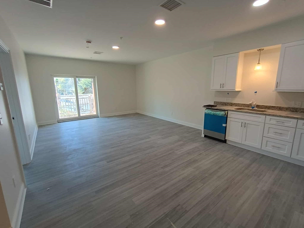 a view of a kitchen with wooden floor and a sink