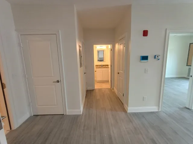 a view of a hallway with wooden floor and closet area