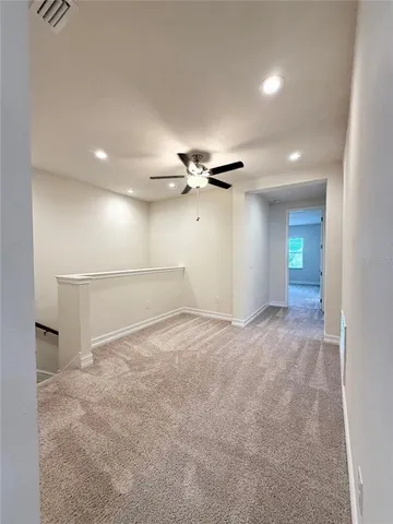 an empty room with a window and a ceiling fan