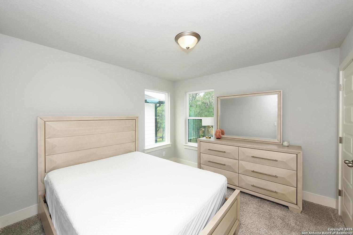 16011 Babcock Road, Unit 13 San Antonio, TX 78255 - Photo 20 of 25 a bedroom with a bed and a dresser