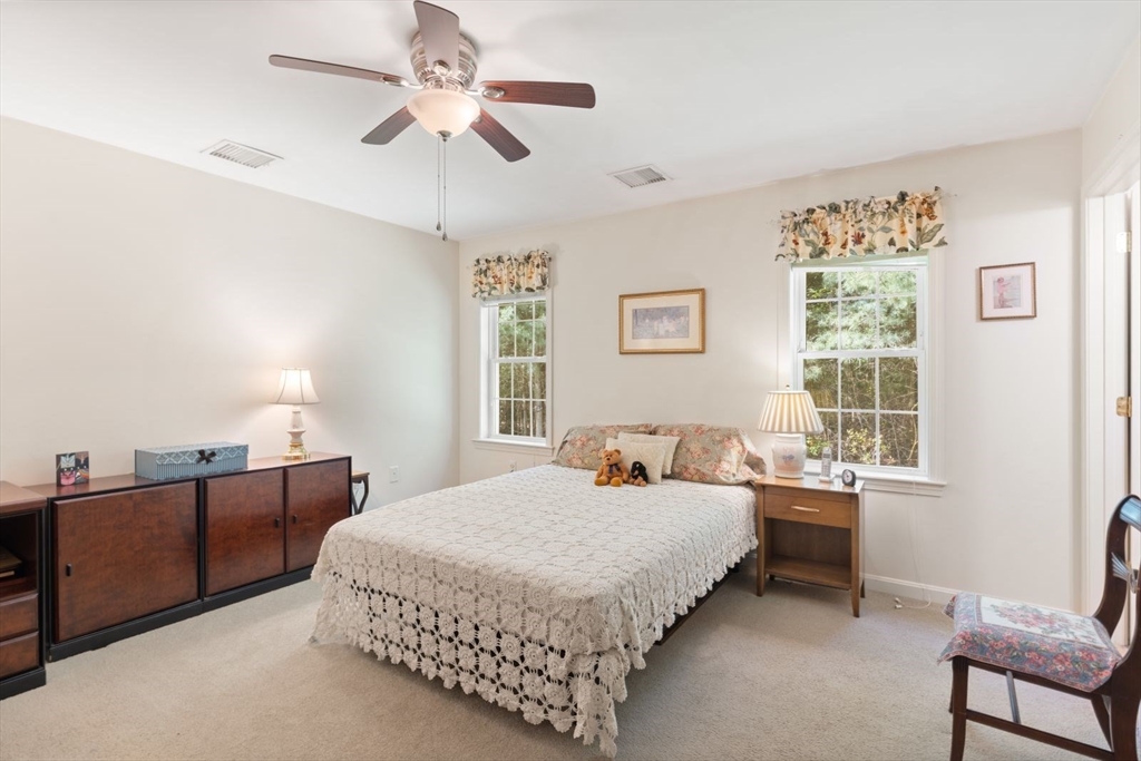 60 Brewster Road, Unit 60 Stoughton, MA 02072 - Photo 11 of 18 a bedroom with a bed chandelier and a window