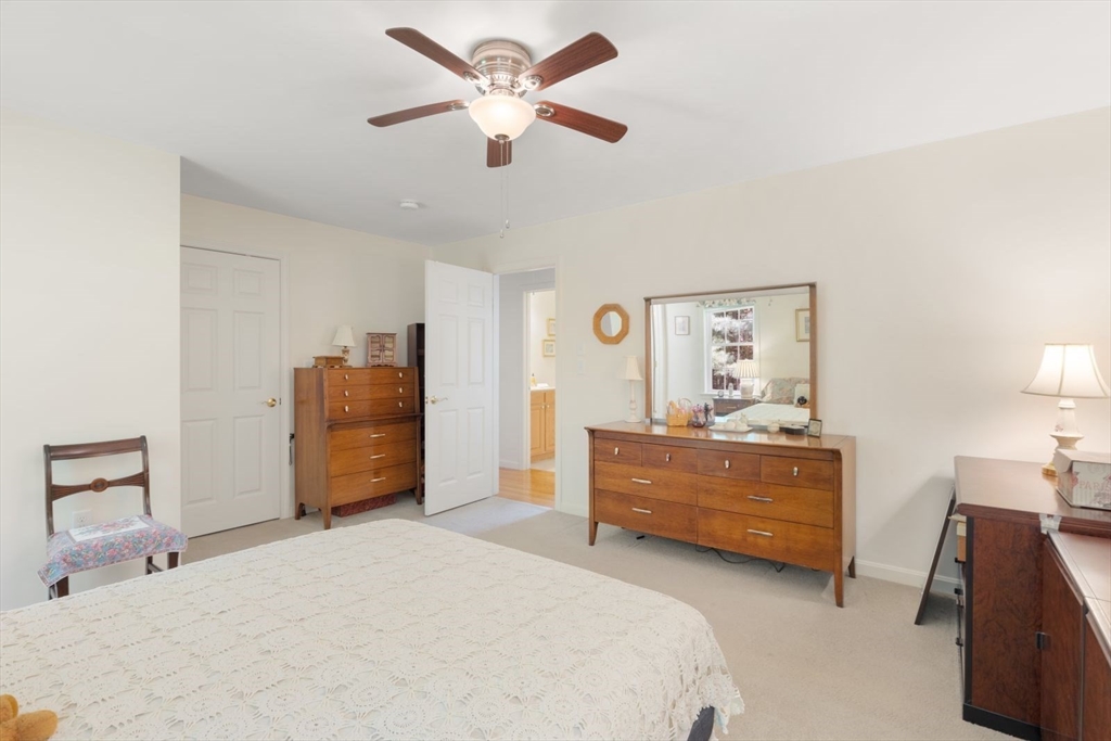 60 Brewster Road, Unit 60 Stoughton, MA 02072 - Photo 12 of 18 a bedroom with a bed and a chandelier