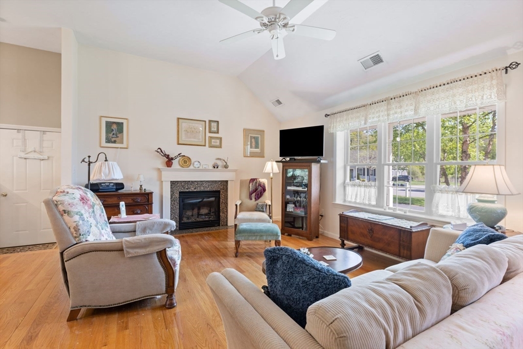 60 Brewster Road, Unit 60 Stoughton, MA 02072 - Photo 2 of 18 a living room with furniture a large window and a fireplace