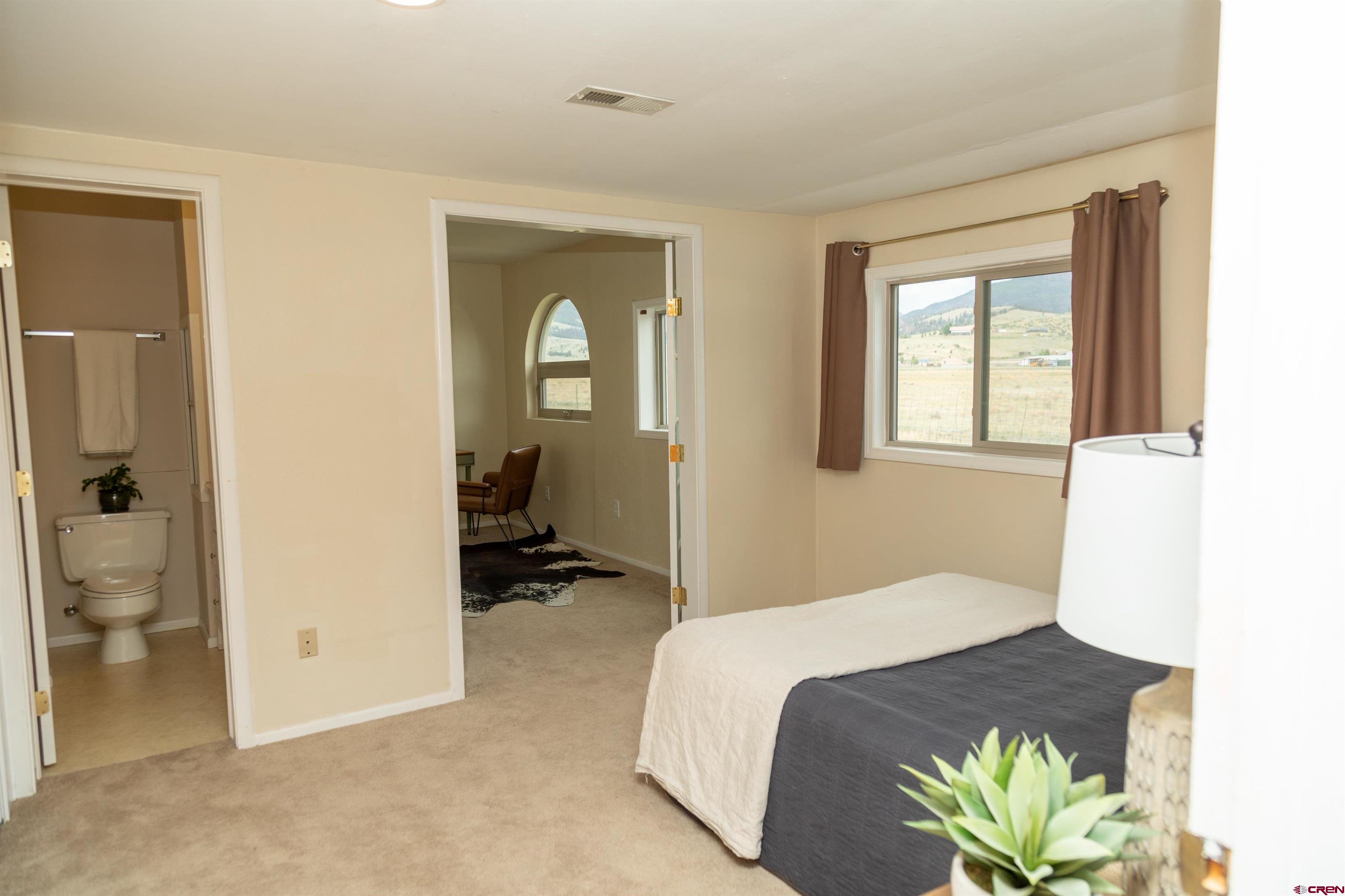 507 Ridge Drive Creede, CO 81130 - Photo 12 of 31 a bedroom with a bed and a chandelier